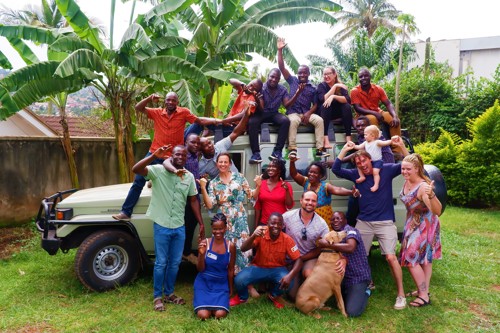 Groepsfoto van Roadtrip Uganda medewerkers voor een groene Landcruiser