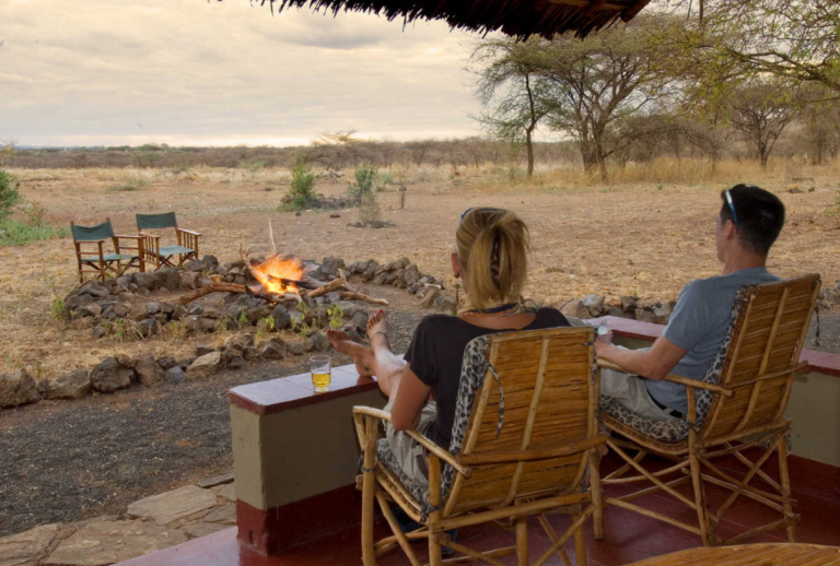 Two people sitting in front of Kenya Banda Kitani Severin camp fire