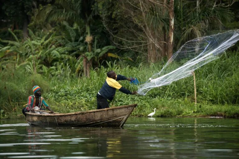 Throwing a fishing net by local men from a boat