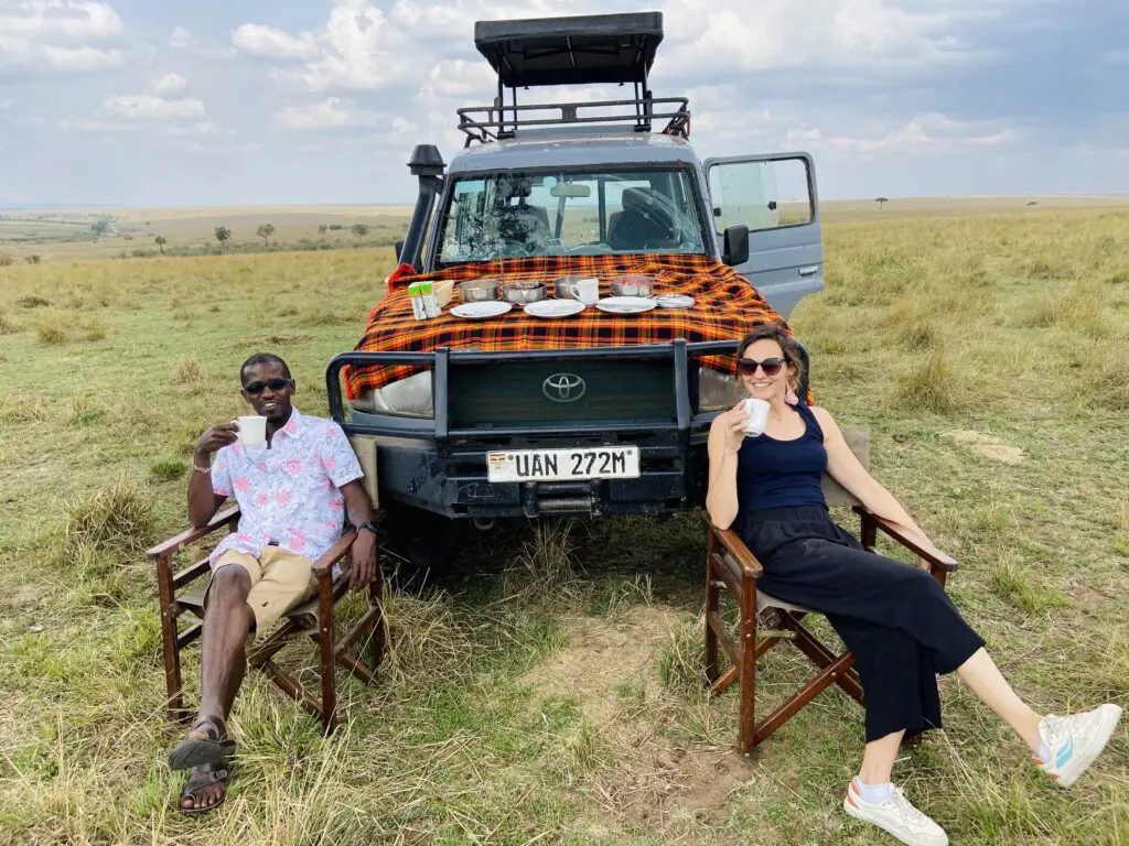 Couple having coffee break in masai mara landcruiser with pop-up roof roadtrip kenya africa