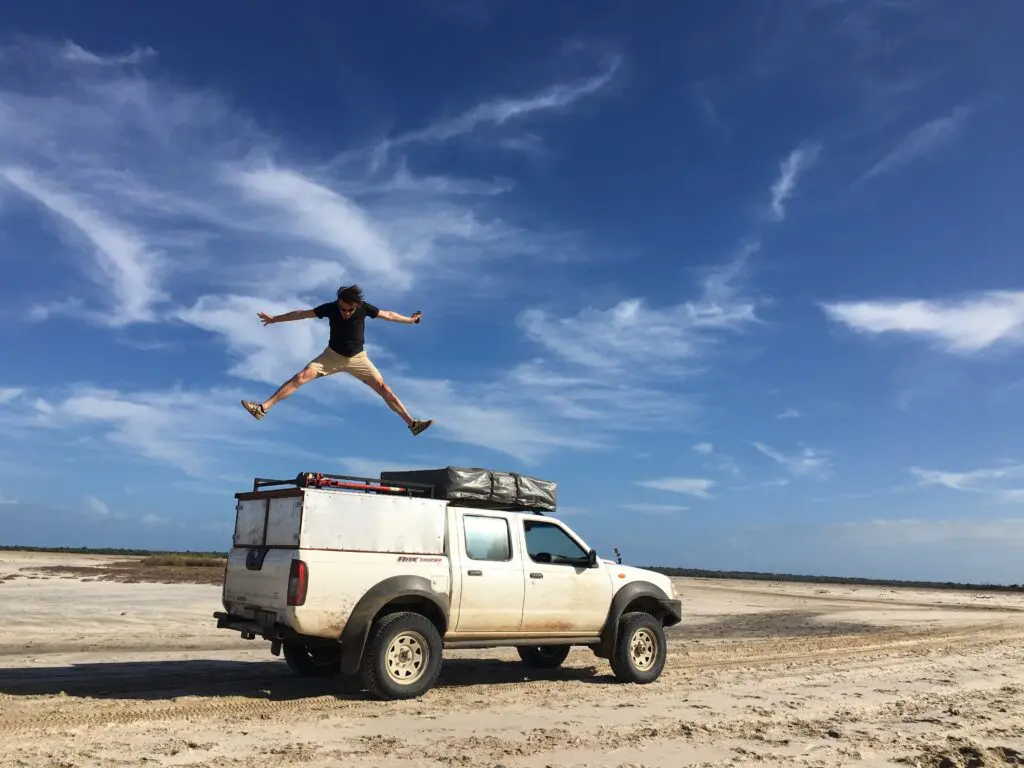 Man Jumping on top of Nissan car from roadtrip madagascar Salt Lake Belo sur mer