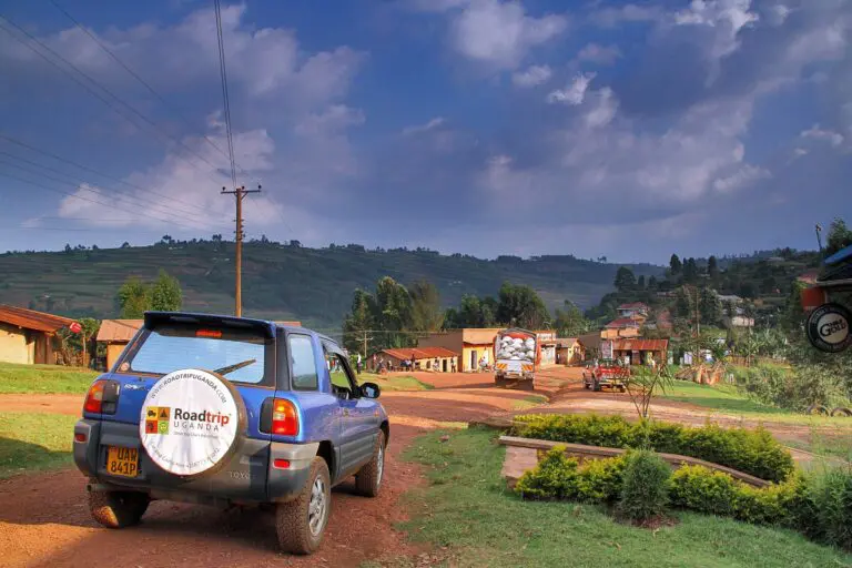 Back view from a blue Toyota RAV4 3-door model near a little village
