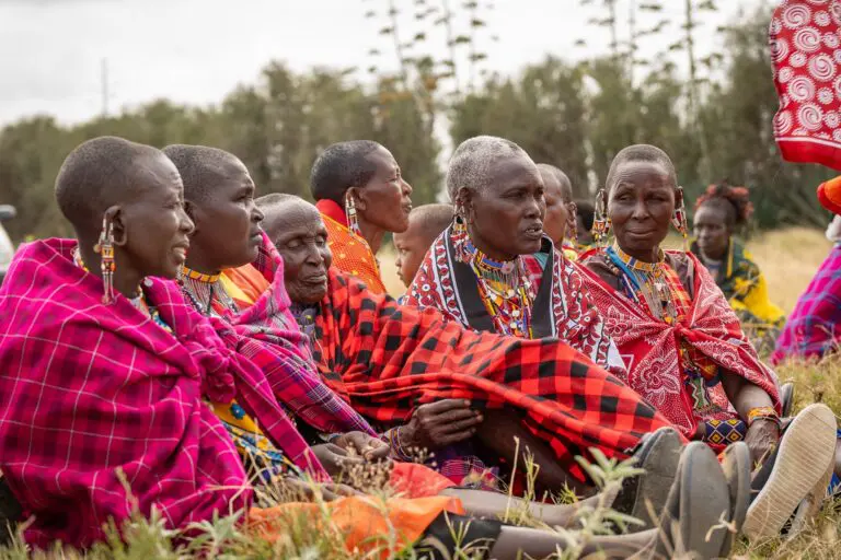group of Maasai women in traditional attire sitting outdoors
