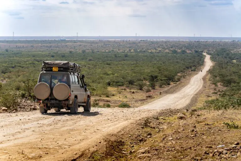 safari vehicle on a dirt road in the Kenyan savanna