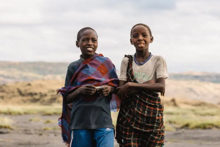 two young Tanzanian boys smiling in traditional clothing