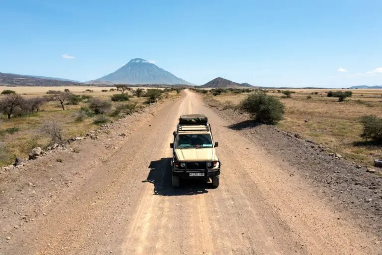 safari jeep on dirt road towards Ol Doinyo Lengai volcano Tanzania