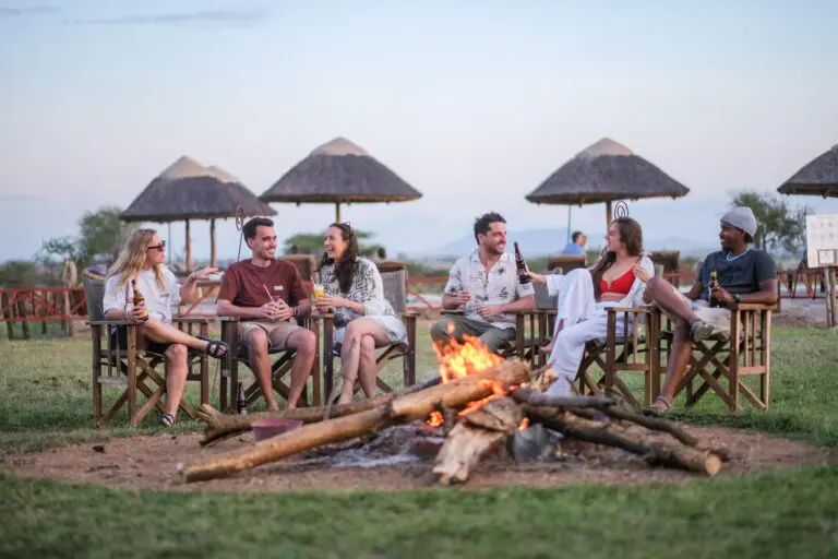 group of friends relaxing around a campfire in Tanzania