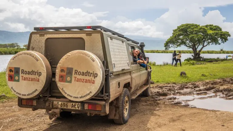people in safari vehicle by lake in Tanzania