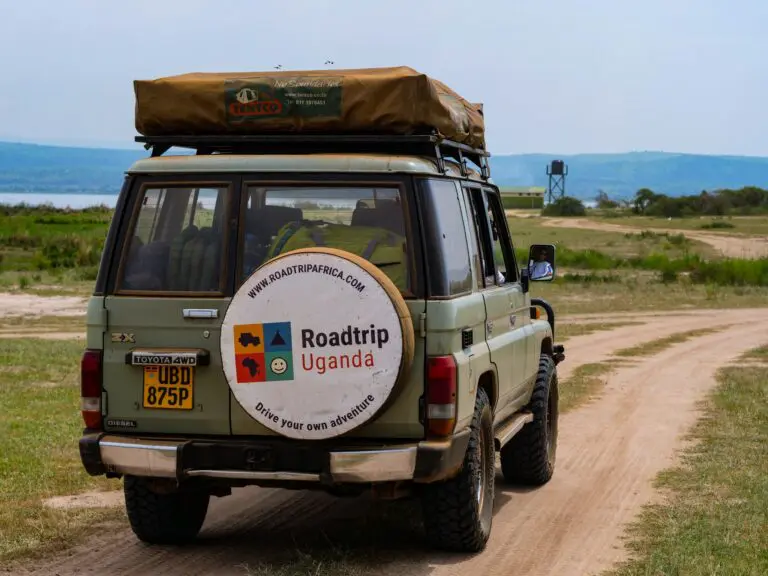 safari jeep with rooftop tent on a dirt road in Uganda