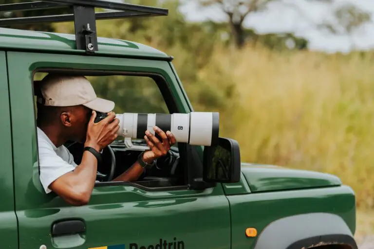 persoon in een safariwagen met een grote telelens